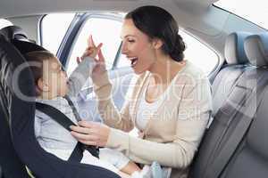 Mother securing her baby in the car seat