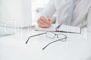 Mid section of a businessman taking notes