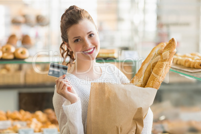 Pretty brunette with bag of bread and credit card