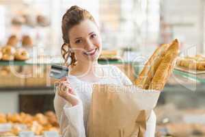 Pretty brunette with bag of bread and credit card