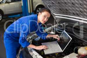 Mechanic using laptop on car