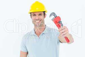 Happy carpenter holding monkey wrench