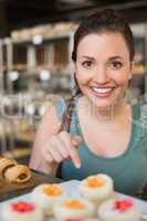 Pretty brunette picking out a cupcake