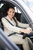 Pretty businesswoman smiling and driving