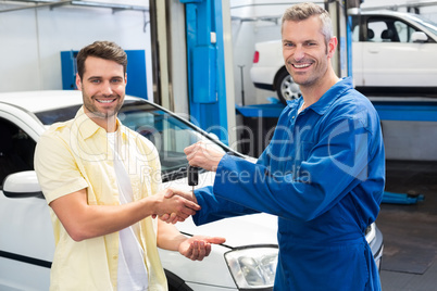 Customer shaking hands with mechanic taking keys
