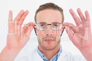 Optician in coat holding glasses