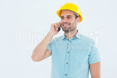 Happy male architect conversing on mobile phone
