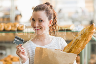 Pretty brunette with bag of bread and credit card