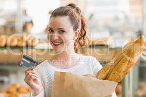 Pretty brunette with bag of bread and credit card