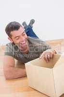 Smiling man open a moving box at home