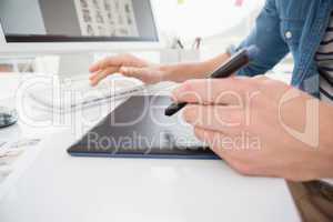 Hands of designer typing on keyboard and using digitizer