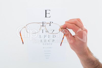 Hand holding glasses for a eye test