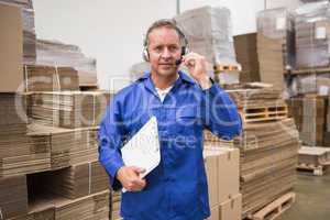 Serious warehouse worker using headset