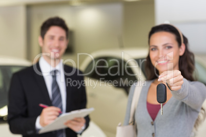 Female driver showing a key after bying a new car