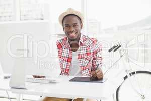 Smiling businessman in straw hat using digitizer