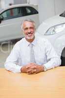 Happy businessman sitting at his desk