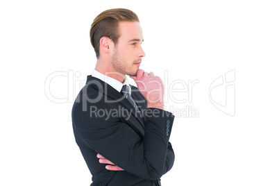 Thinking businessman standing with hand on chin