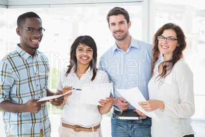 Smiling coworkers holding files and posing