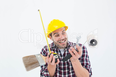 Happy repairman holding various tools