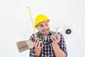 Happy repairman holding various tools