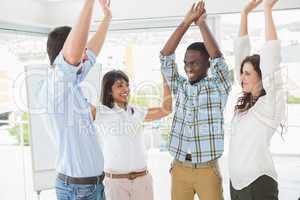 Happy coworkers standing and cheering together