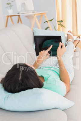 Brunette using her tablet on sofa