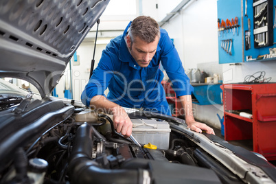 Mechanic examining under hood of car