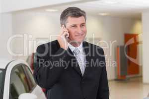 Smiling businessman calling with his mobile phone