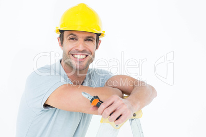 Technician holding pliers while leaning on ladder