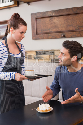 Waitress bringing man coffee and tart