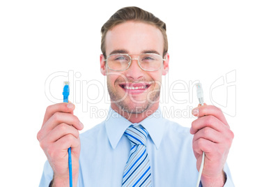 Geeky businessman holding two cables