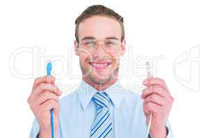 Geeky businessman holding two cables