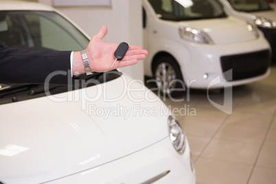 Close up of salesman showing car key