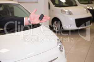 Close up of salesman showing car key