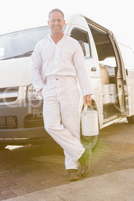 Painter smiling leaning against his van