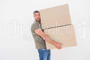 Man carrying cardboard moving boxes at home