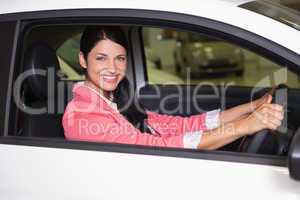 Smiling woman sitting at the wheel of her new car