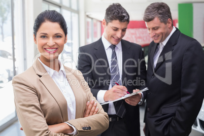 Businessman writing on clipboard talking to colleague