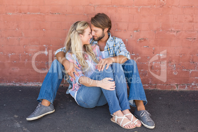 Attractive couple sitting on ground