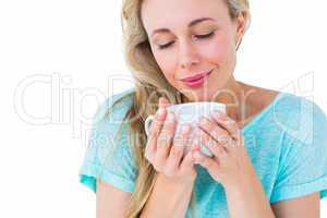 Smiling blonde with hot beverage relaxing