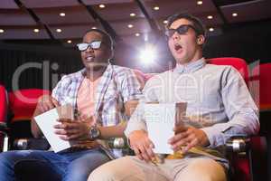 Astonished young friends watching 3d film