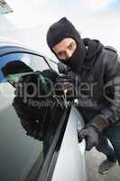 Thief breaking into a car