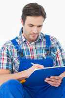 Plumber writing notes on clipboard