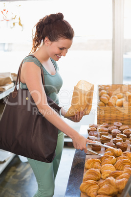 Pretty brunette picking out croissant