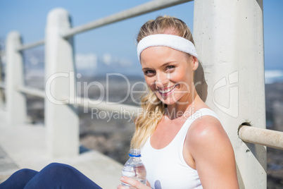 Fit blonde sitting on the pier