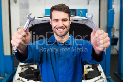 Mechanic holding pair of wrenches