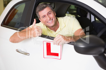 Man gesturing thumbs up holding a learner driver sign