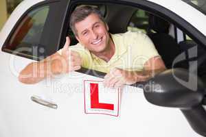 Man gesturing thumbs up holding a learner driver sign
