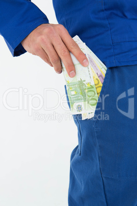 Construction worker putting euro notes in pocket