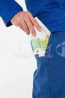 Construction worker putting euro notes in pocket